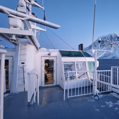 A boat deck looking out to snow-covered mountains