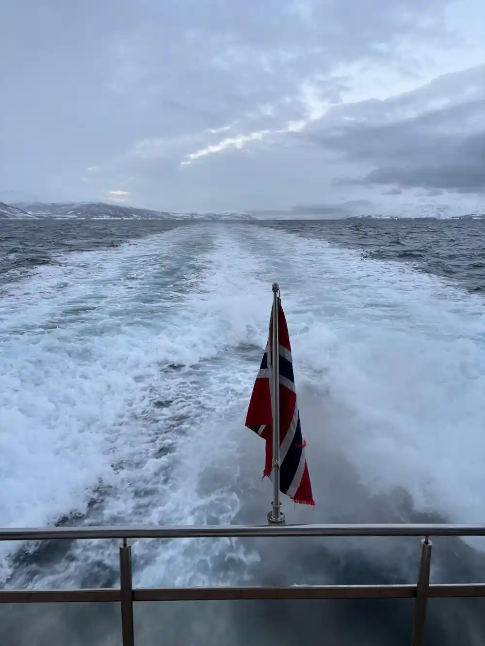 Boat deck with flag and rough waves ahead