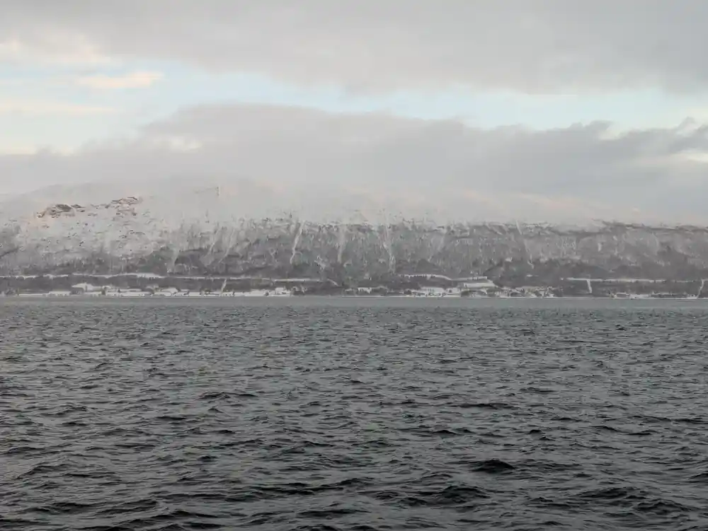Snow-covered mountains across water from boat viewpoint