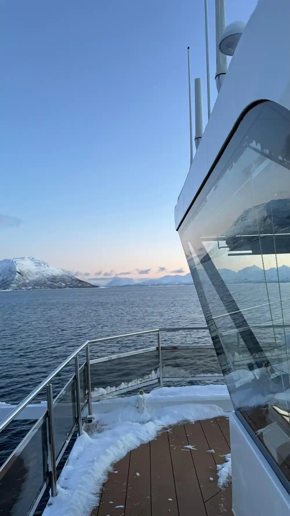 Sunset from boat deck with snow mountains across water