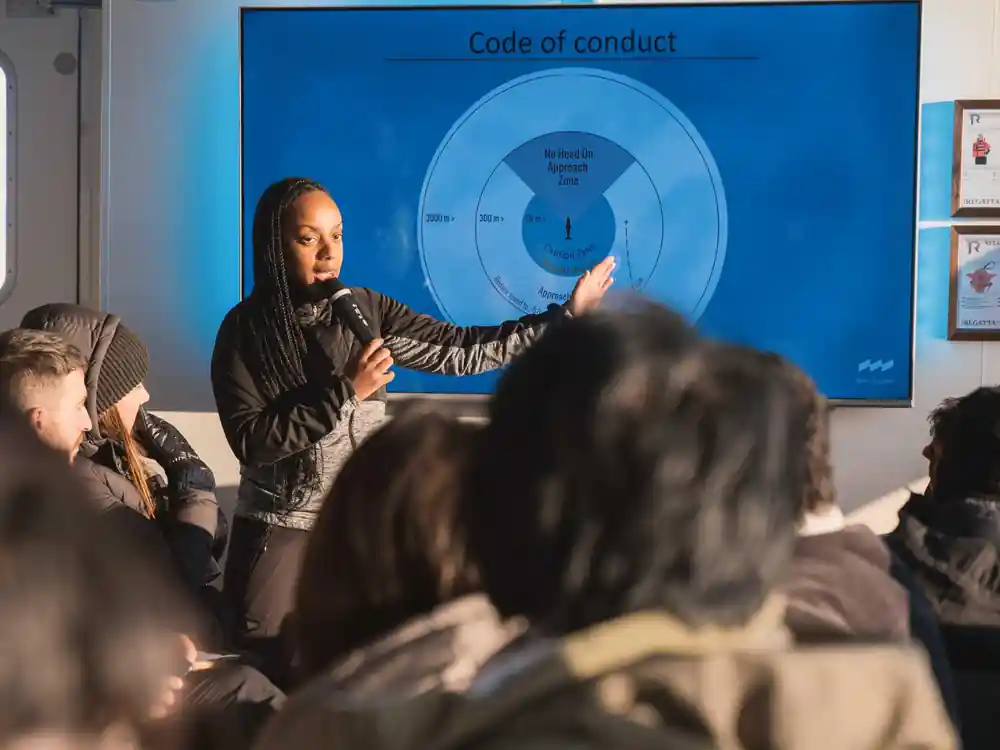 Woman presenting code of conduct diagram to group of people
